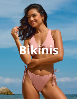 Woman wearing a chic pink bikini from the Seatonic brand, enjoying a sunny beach backdrop. 